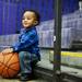 Eighteen-month-old Nation Roney plays with a basketball and watches his uncle play in the Pioneer junior varsity game on Friday, Feb. 1. Daniel Brenner I AnnArbor.com